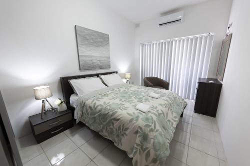 a bedroom with a bed and a chair in it at Seaside Escape Birzebbuga in Birżebbuġa