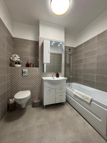 a bathroom with a sink and a toilet and a tub at Alia Residence in Buzau