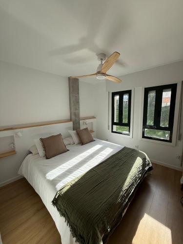 a bedroom with a large bed with a ceiling fan at Casa do Tititos in Baiona