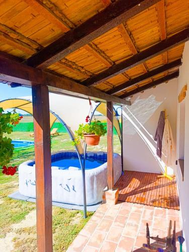 a patio with a hot tub under a wooden roof at Ruralna kuća za odmor Bor Anya in Vardarac