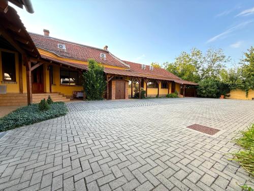 ジュラにあるToscana Apartmanのレンガ造りの私道が目の前にある建物