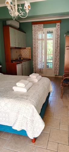 a bedroom with a large bed and a kitchen at Edem Studios in Sivota