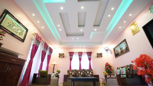 a living room with a coffered ceiling and curtains at Aruvi Homestay in Kodaikānāl