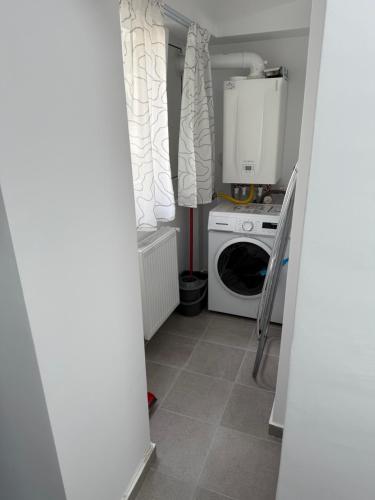 a small laundry room with a washer and dryer at Apart Hotel G1 in Roman