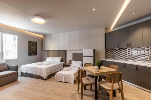 テッサロニキにあるNoima Luxury Suitesのベッドとテーブルとキッチンのある寝室