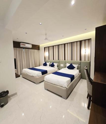two beds in a hotel room with at Hotel Sai Residency in Pune