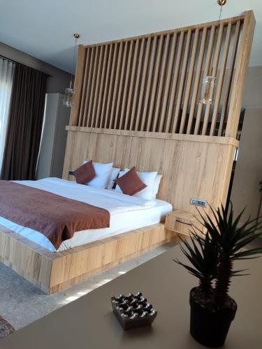 a bedroom with a large bed with a wooden headboard at Melekona House in Kartepe