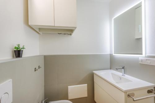 un bagno bianco con lavandino e WC di Corso Adriano 13 - I Giardini a Modena