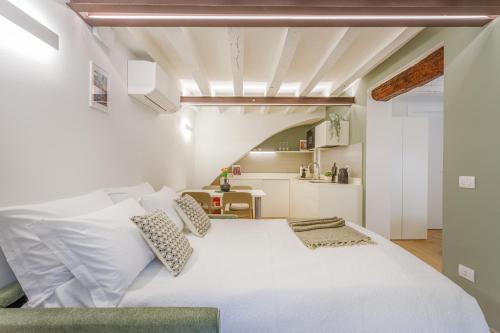 una camera da letto con un letto bianco e una cucina di Corso Adriano 13 - I Giardini a Modena