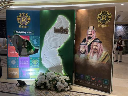 a display of posters in a room with flowers at راجان للشقق المخدومة in Taif