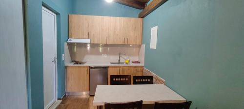 a kitchen with a table and chairs in a room at Edem Studios in Sivota