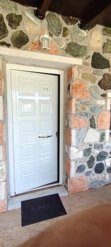a white garage door in a stone wall at Edem Studios in Sivota