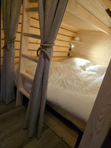ein Bett in einem Holzzimmer mit einem Etagenbett in einer Hütte in der Unterkunft Le Petit Cocon - Proche des pistes - Alp'in C in Châtel