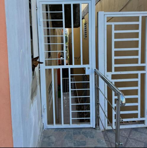 a dog looking through the door of a gate at Apartamento la familia 2 in Santa Bárbara de Samaná