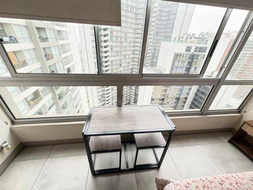 a room with a table in front of a large window at SantiagoCentral in Santiago