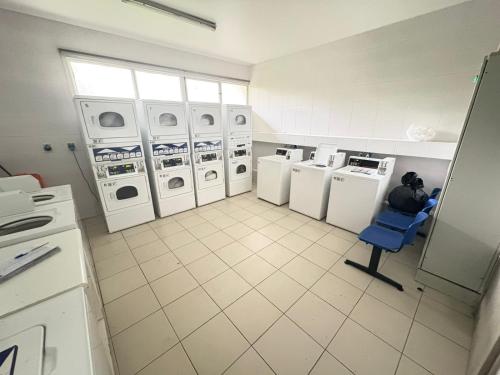 a laundry room with several washing machines and a blue chair at SantiagoCentral in Santiago