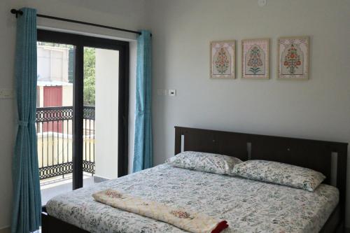 チェンナイにあるTara Spacious 3BHK Virugambakkamのベッドルーム1室(ベッド1台付)、バルコニーへのドアが備わります。