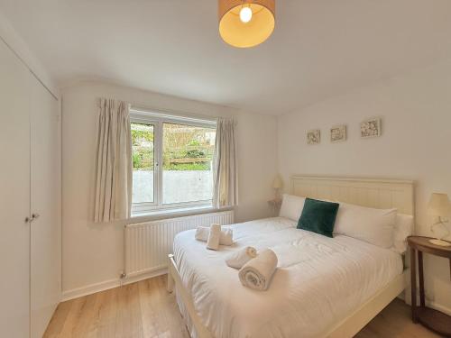 a bedroom with a white bed with towels on it at 3 bedroom cottage in the heart of Topsham with river views and parking in Topsham