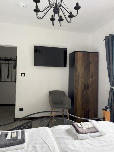a bedroom with a bed and a chair and a tv at Hotel Plzeňský Dvůr in Frýdek-Místek