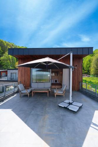 a patio with an umbrella and chairs on a roof at Melekona House in Kartepe
