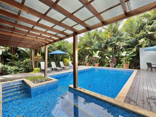 an outdoor swimming pool with a wooden pergola and a swimming poolvisor at Standard King Room in Punta Uva