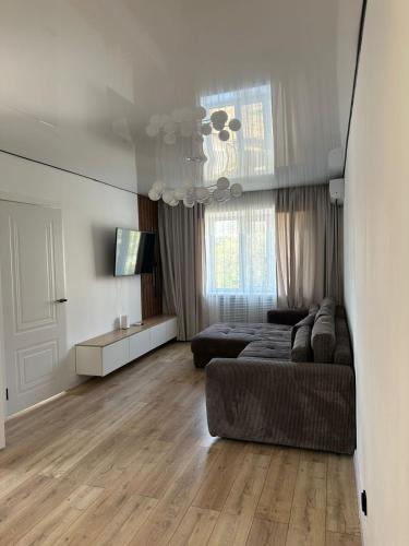 a living room with a couch and a bed at современная квартира рядом с парком in Taraz