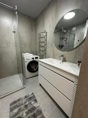 a bathroom with a sink and a washing machine at современная квартира рядом с парком in Taraz
