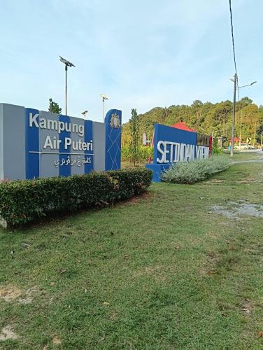 a couple of signs in a grass field at Air Puteri Rest House in Mersing