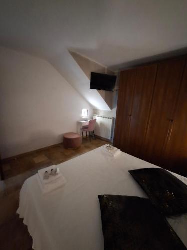 a bedroom with a bed with white sheets and a table at La Casa di Mia in Monterotondo