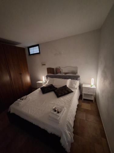 a bedroom with a bed with white sheets and two lamps at La Casa di Mia in Monterotondo