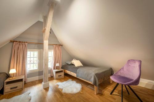 una camera con letto e sedia viola di Villa Margaret a Lądek-Zdrój
