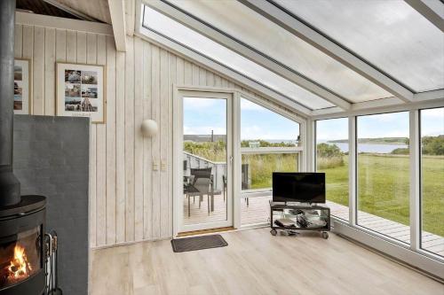 a living room with a fireplace and a screened in porch at G608-Lemvig-Gyvelvej-8 in Lemvig