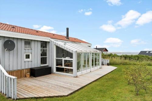 a house with a wooden deck with a greenhouse at G608-Lemvig-Gyvelvej-8 in Lemvig