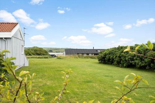 a yard with a white building and a grass field at G608-Lemvig-Gyvelvej-8 in Lemvig