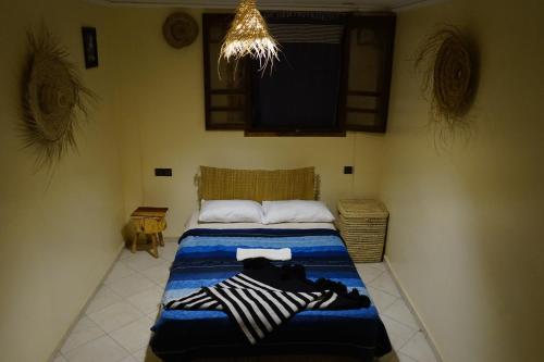 a bedroom with a bed with a blue comforter at Bright Wave Surfhouse in Tamraght Ouzdar
