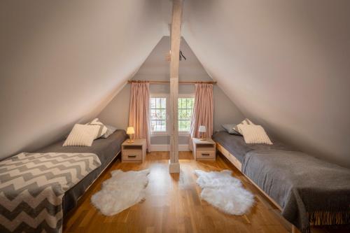 a attic room with two beds and a window at Villa Margaret Centrum Regeneracji i Odnowy Biologicznej in Lądek-Zdrój