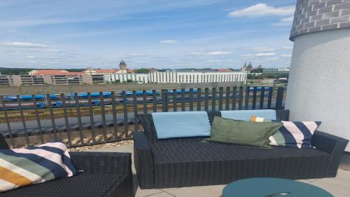a patio with a couch and pillows on a balcony at Holiday Inn - the niu, Sparrow Regensburg by IHG in Regensburg