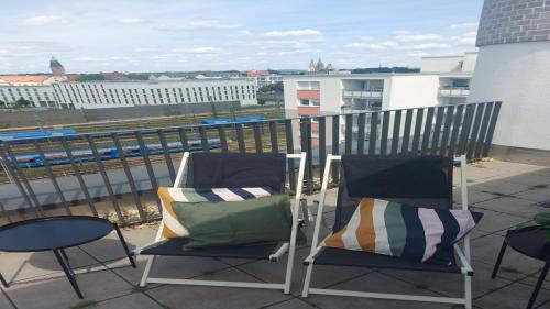 two chairs sitting on top of a balcony at Holiday Inn - the niu, Sparrow Regensburg by IHG in Regensburg