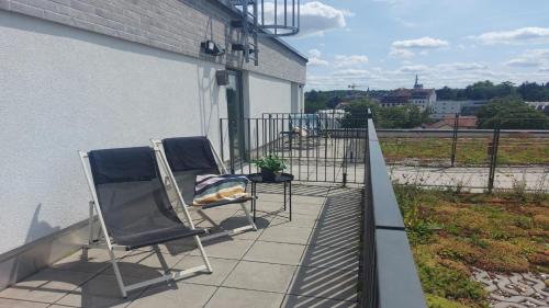 two chairs sitting on the balcony of a building at Holiday Inn - the niu, Sparrow Regensburg by IHG in Regensburg