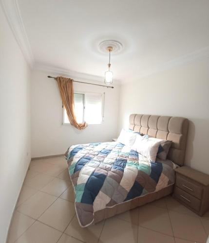 a bedroom with a bed and a window at Appartement moderne - Résidence privée in Kenitra