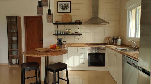a kitchen with a table and two stools in it at Casa de las Montañas in Parcent