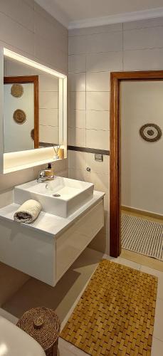 a white bathroom with a sink and a mirror at Casa de las Montañas in Parcent
