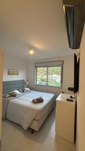 a bedroom with a large bed and a window at Flat 3 suites frente mar in Florianópolis