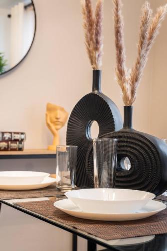 a table with plates and glasses on a table with vases at Departamento cerca de Estadio GNP y Aeropuerto in Mexico City