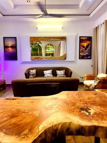 a living room with a wooden table and a couch at 2 chambre 1 Selon a Cotonou stade in Cotonou