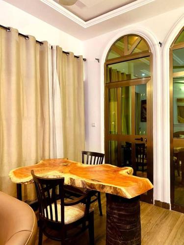 a dining room with a wooden table and chairs at 2 chambre 1 Selon a Cotonou stade in Cotonou