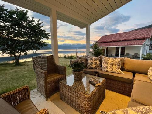 a screened in porch with a couch and chairs at Charming house by the fjord in Utvik