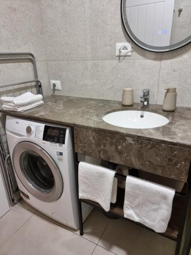 a bathroom with a sink and a washing machine at KC Apartments 3 in Berat
