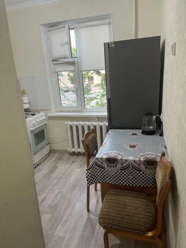 a kitchen with a table and chairs in a room at Авангард 4-12 in Atyraū