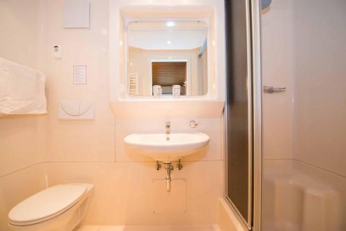 a bathroom with a sink and a toilet and a shower at Frühstückspension Zippo in Greifenburg
